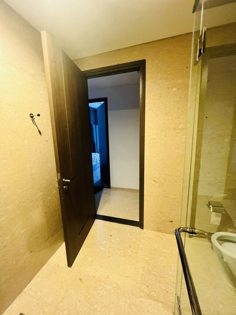 Pintu masuk ke kamar mandi dari koridor atau kamar tidur di dalam unit apartemen 31 Sudirman Suites Makassar.