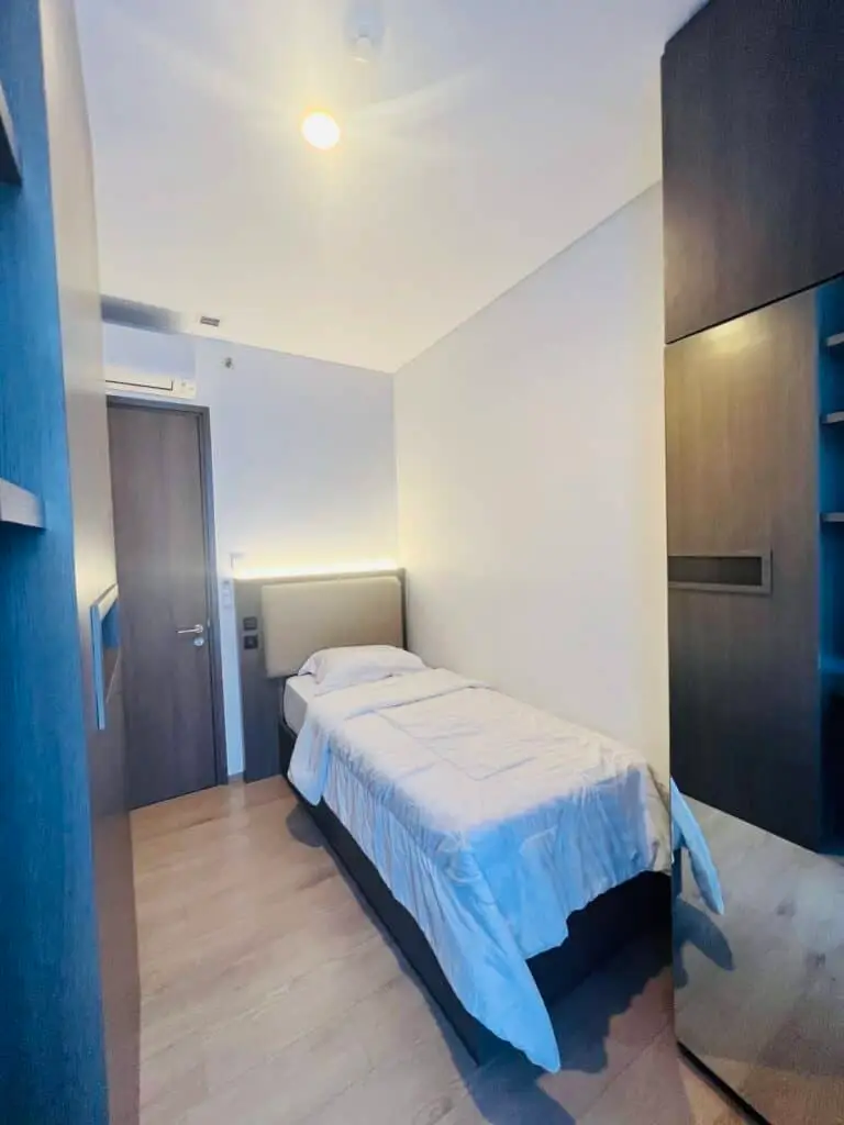 Kamar tidur dengan lemari pakaian berpintu cermin di apartemen 31 Sudirman Suites Makassar.