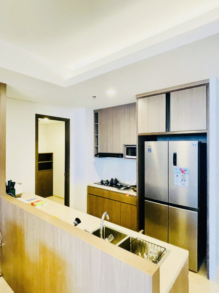 Dapur apartemen 31 Sudirman Suites Makassar dengan akses ke area servis, menunjukkan kelengkapan unit 3 kamar + 1.