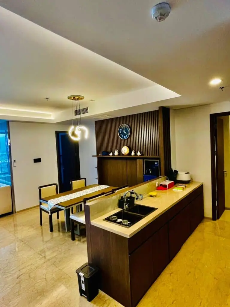 Tampilan ruang makan dan dapur kering (pantry) berkonsep open-plan di dalam unit apartemen 31 Sudirman Suites Makassar 3 kamar + 1.